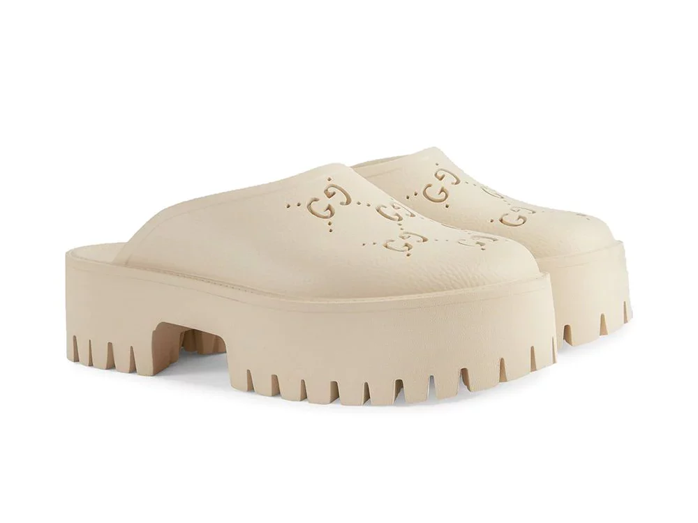 Nude colored mules with Gucci logos and lug soles.