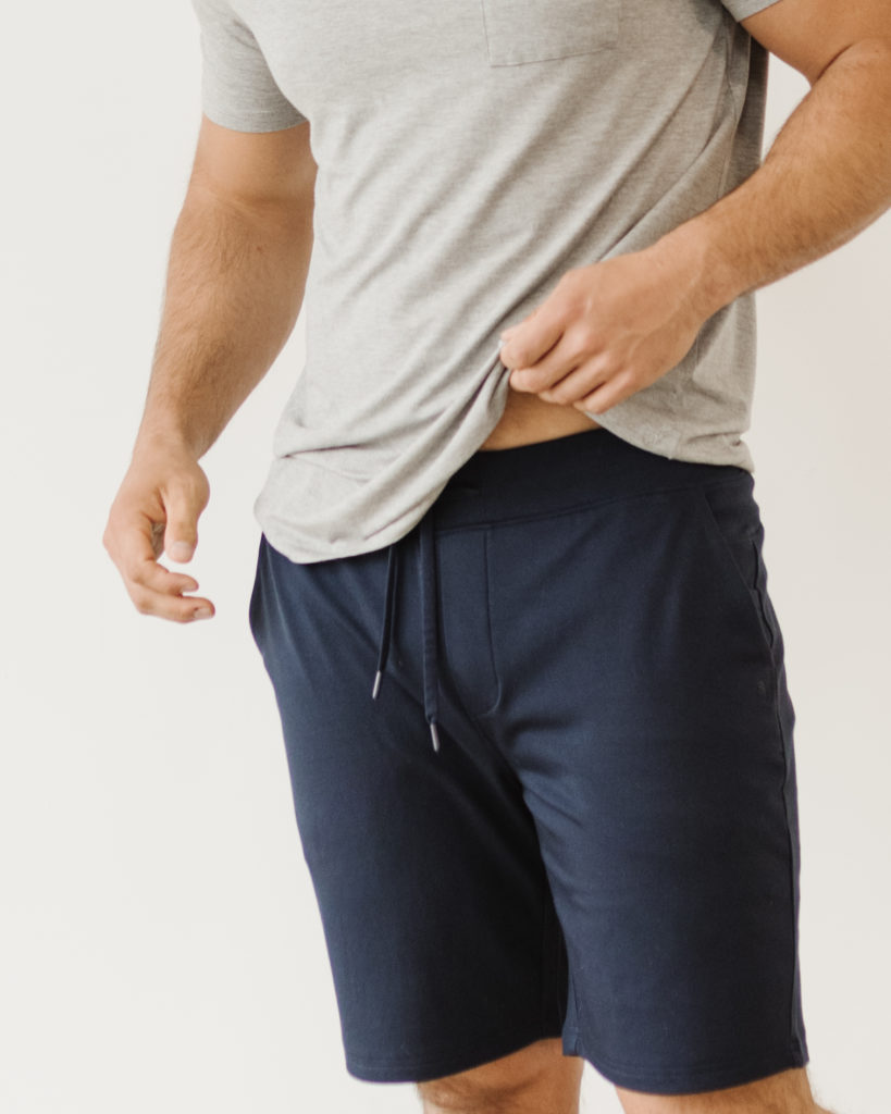 Model wearing navy blue sweatshorts.